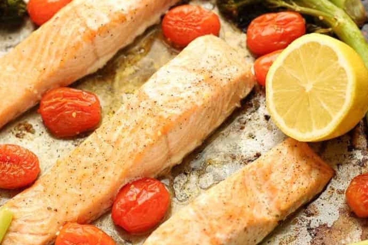 Salmon, broccoli and tomatoes on a baking sheet - a delightful and healthy combination that is perfect for meal prep or weeknight dinners. These three ingredients come together effortlessly on a single baking sheet, creating