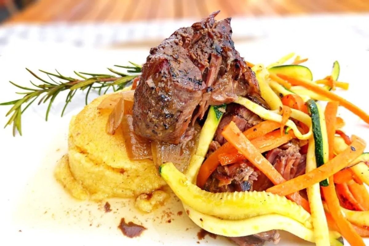 A plate with meat, vegetables and mashed potatoes.