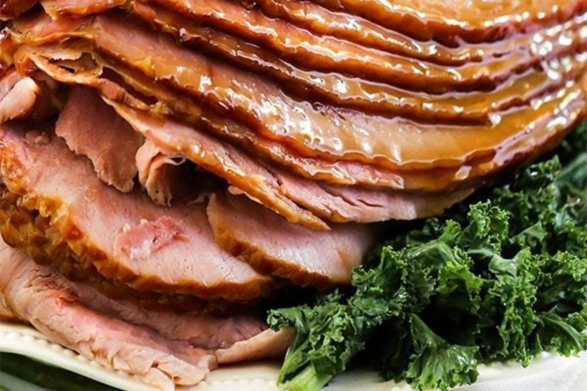 A simple ham is sitting on a plate with elegant kale for New Year's Eve.