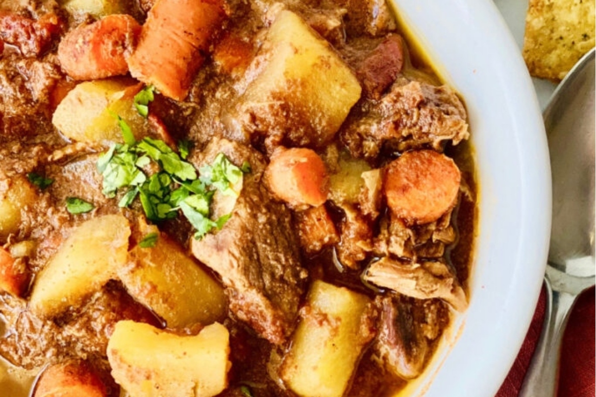 A bowl of beef stew with potatoes and carrots.