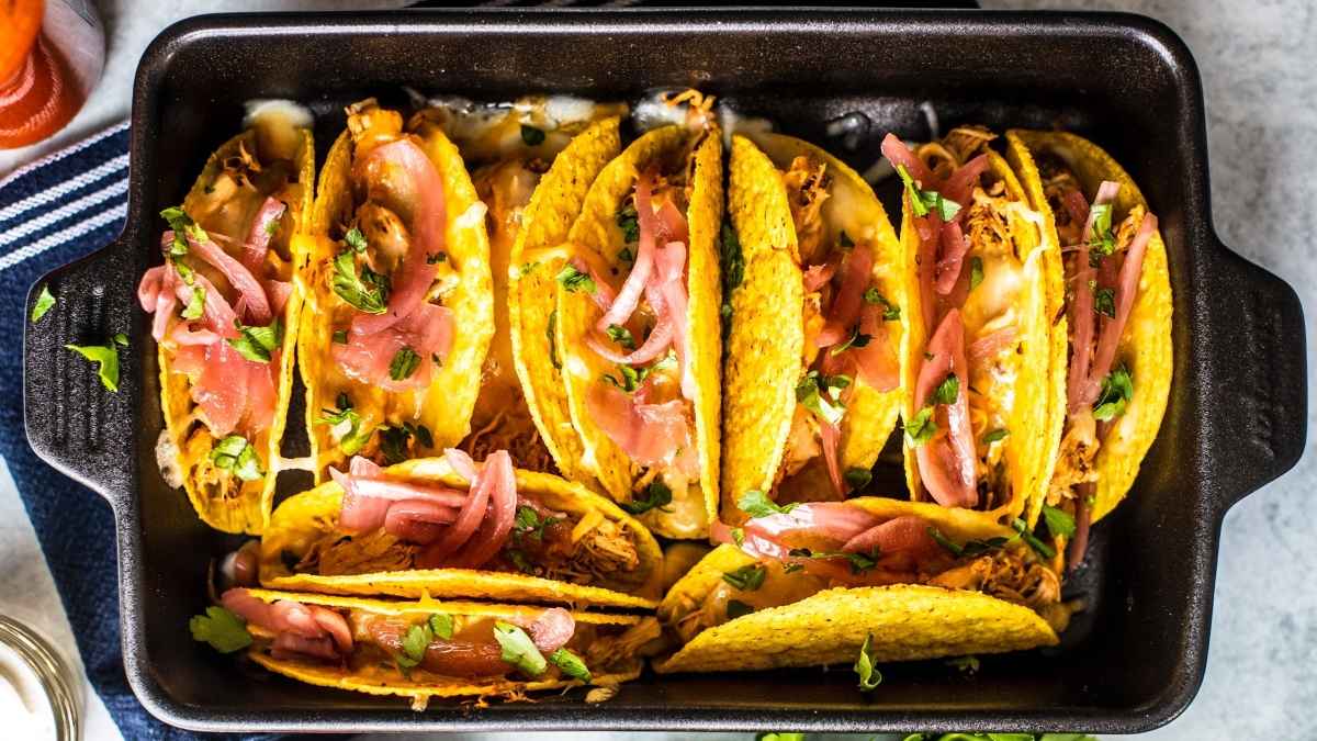 Slow cooker chicken tacos with onions and salsa.