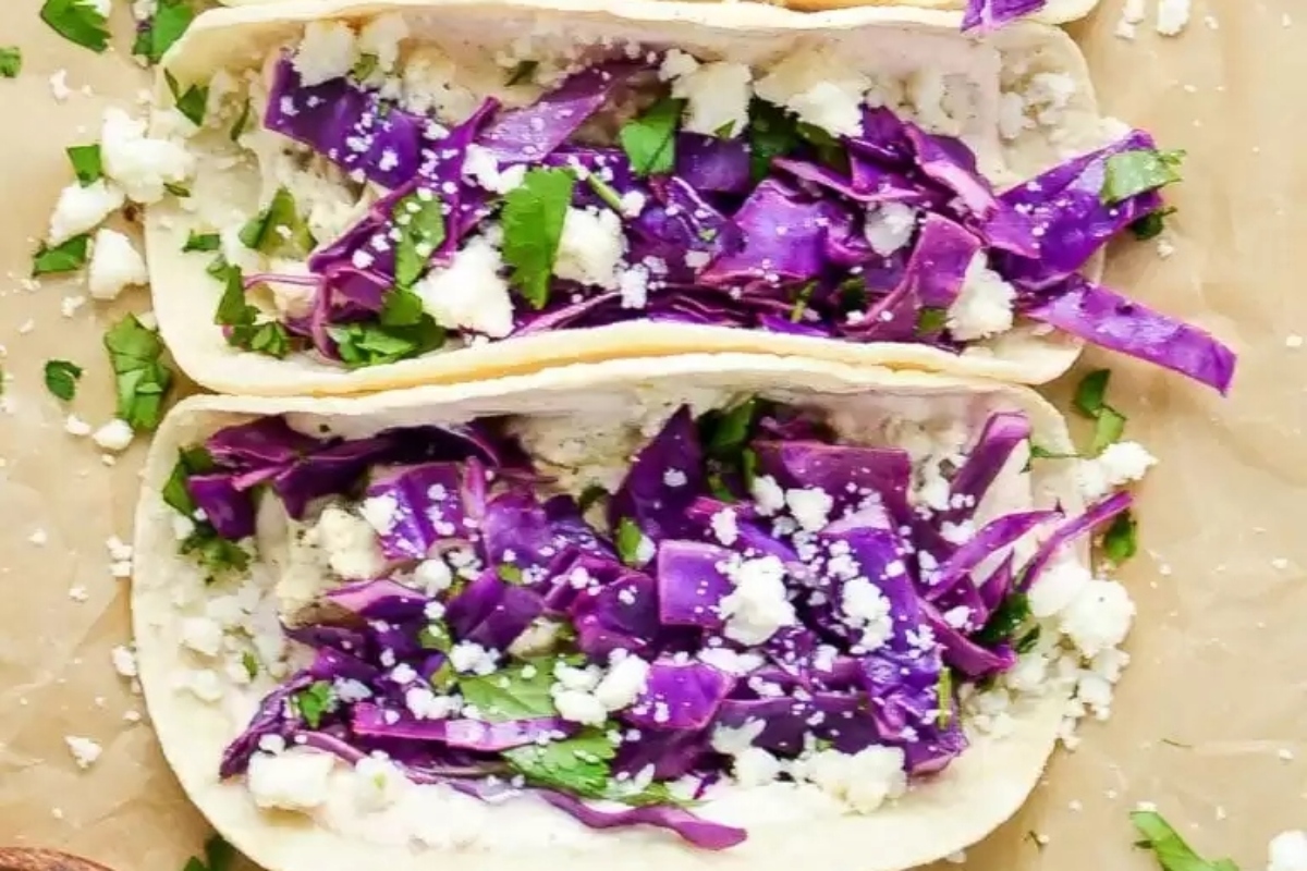 Purple cabbage tacos with feta cheese and sour cream are a delicious option for taco night.