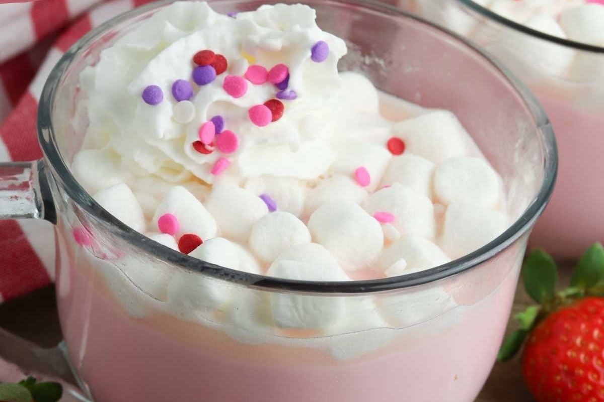 A cup of strawberry hot chocolate topped with whipped cream.