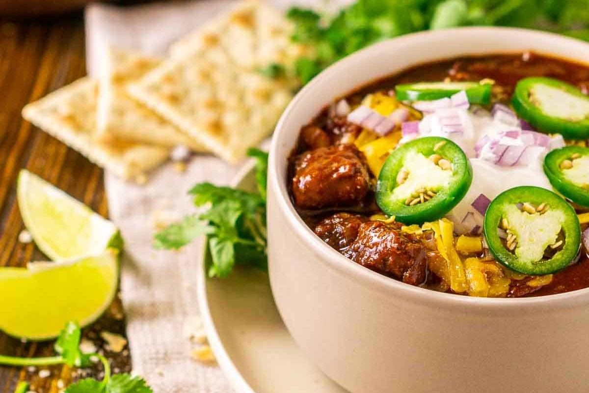 A delicious chili recipe topped with sour cream and jalapenos.