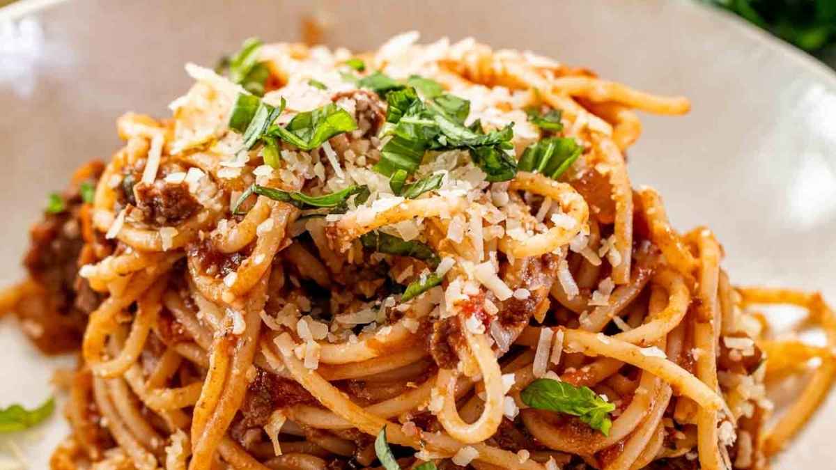 Spaghetti bolognese with grated cheese on top.