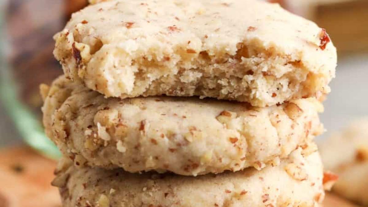 A stack of peanut butter cookies on a wooden cutting board, perfect for trying out new cookie recipes.
