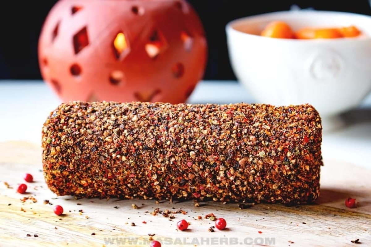 A Cheesy bread appetizer with peppers and spices on a wooden cutting board.
