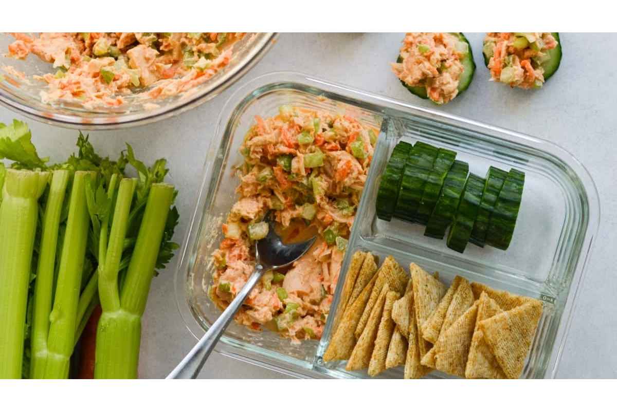 A tray of healthy carrot and celery dip with crackers and celery sticks, perfect for high protein lunches.