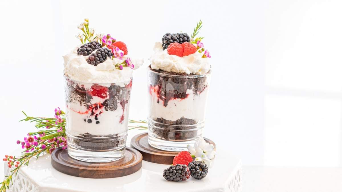 A shared round up of two no bake desserts featuring glasses adorned with whipped cream and berries on top.