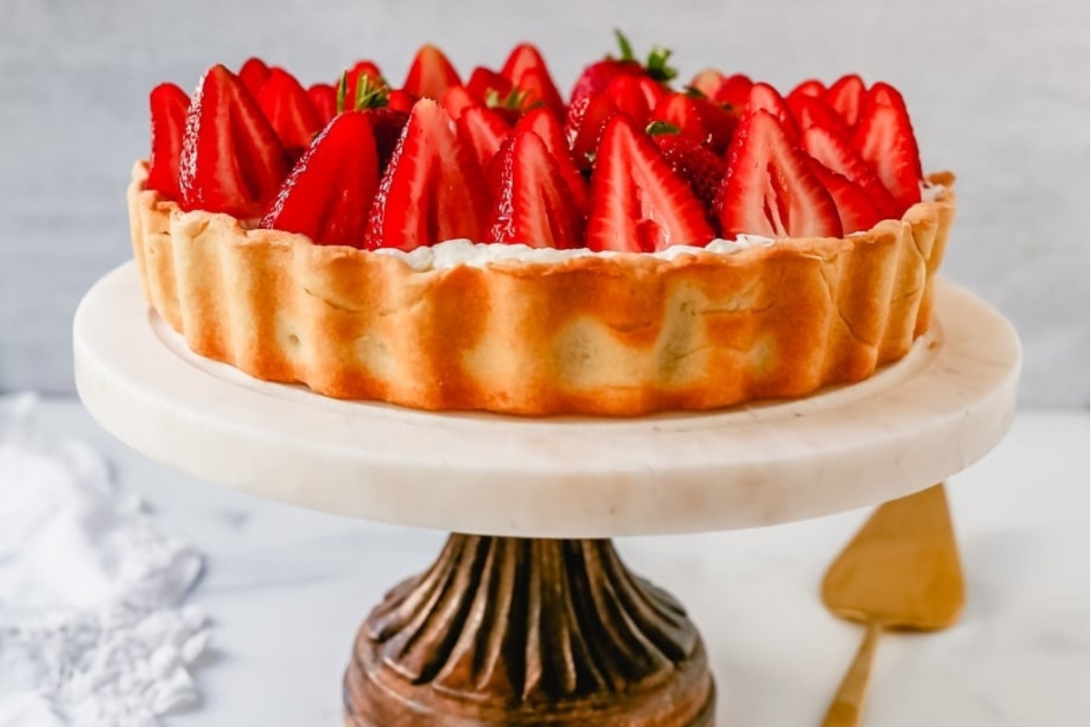 A mouthwatering strawberry tart displayed on a cake stand.