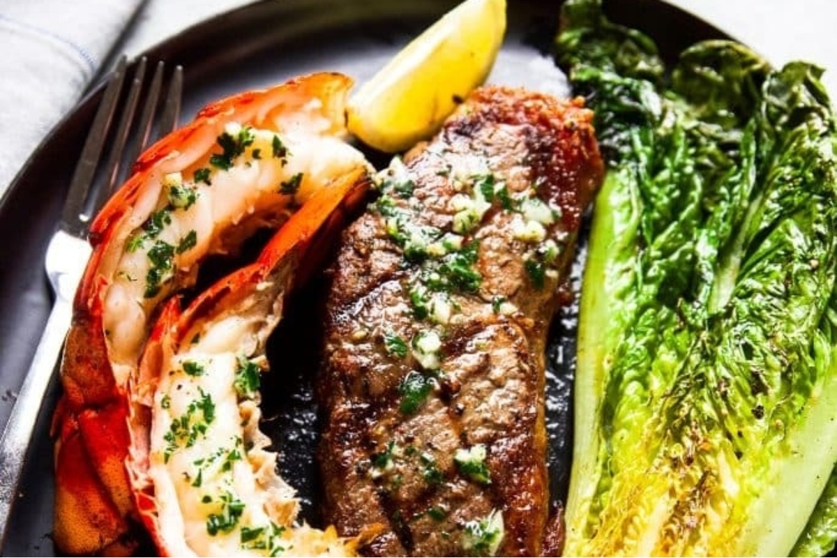 Surf and turf on a plate with lettuce and lemon.
