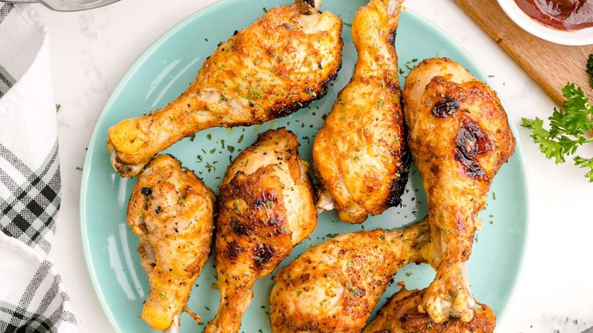 Grilled chicken legs on a blue plate.
