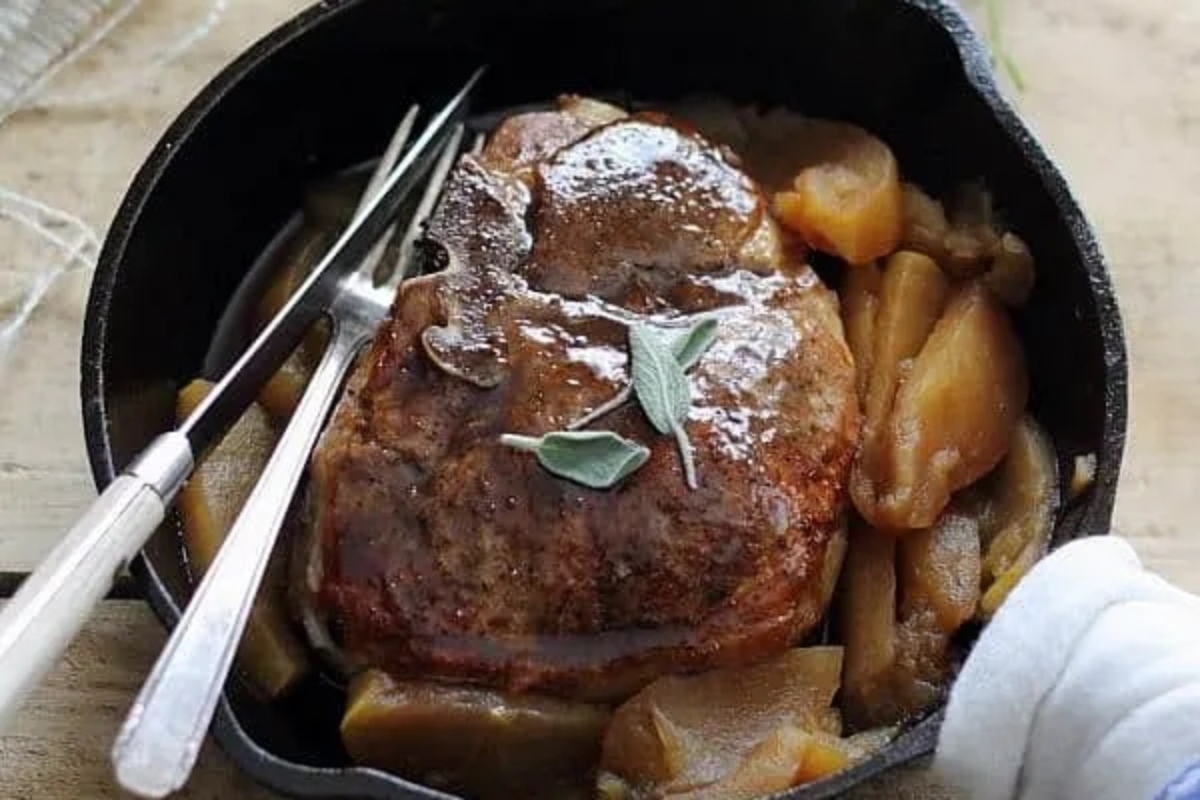 Winter dinner of pork tenderloin with apple and sage in a cast iron skillet.