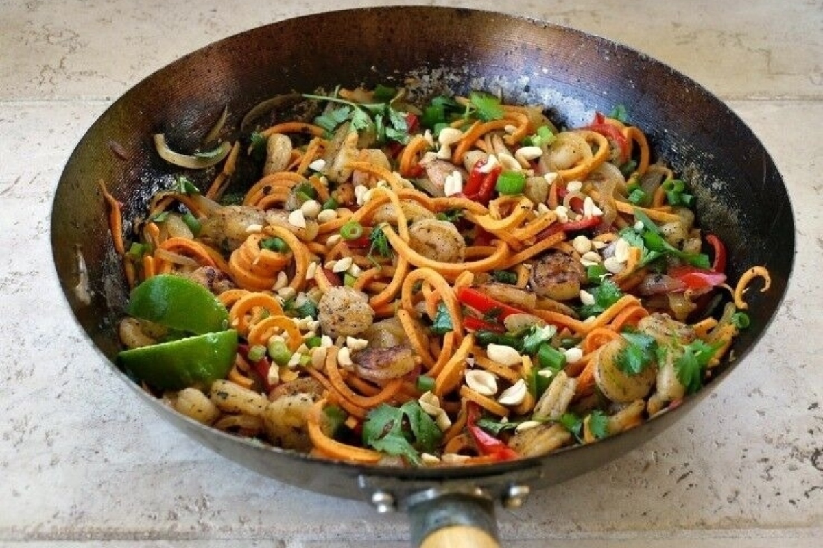 A wok filled with spiralized noodles and vegetables.