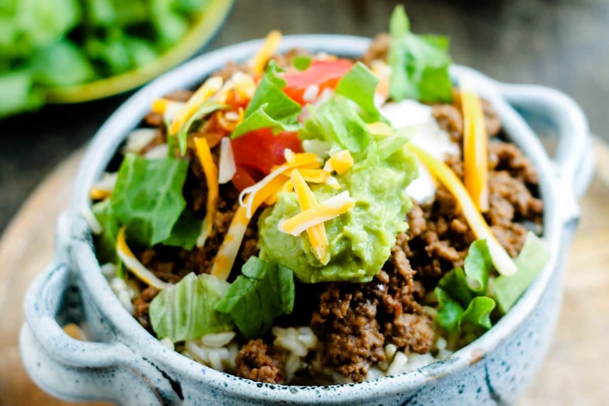 A flavorful bowl of Mexican rice with tender beef and creamy guacamole.