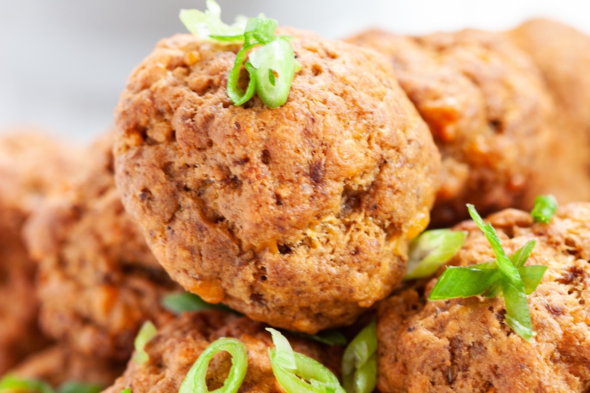 A mouthwatering pile of meatballs with a dash of green onions on top, perfect for Game Day feasting.