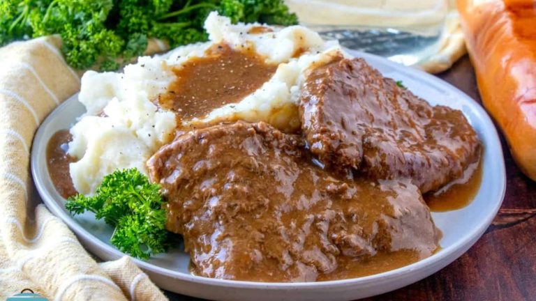 Meatloaf with gravy and mashed potatoes on a plate.