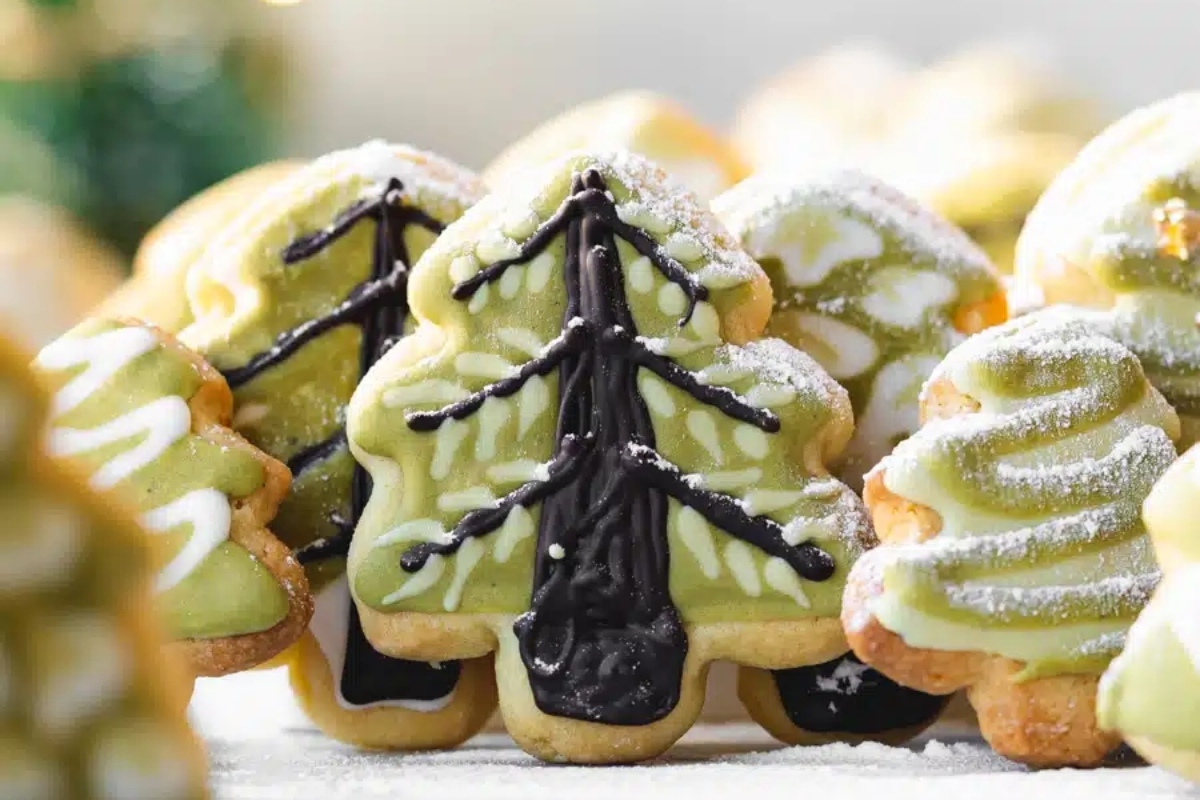 Festive Christmas sugar cookies decorated with green frosting and powdered sugar.