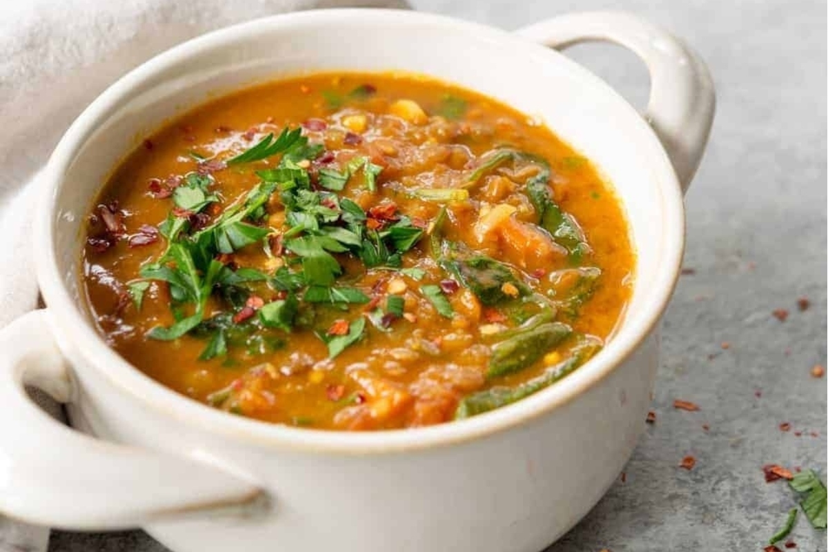 A delicious bowl of vegetable soup with herbs.