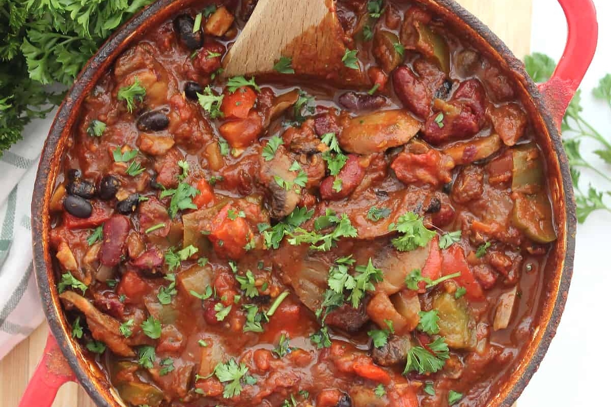Chili recipes in a skillet with a wooden spoon.