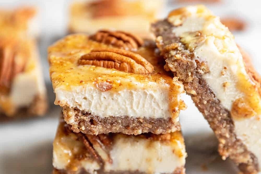 Delicious pecan cheesecake bars stacked on top of each other.