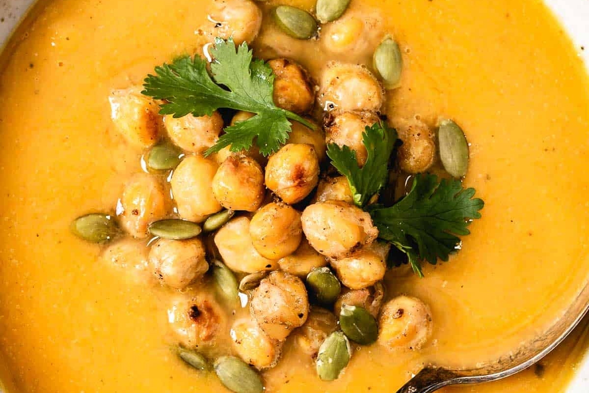 A bowl of potato soup with chickpeas and parsley.