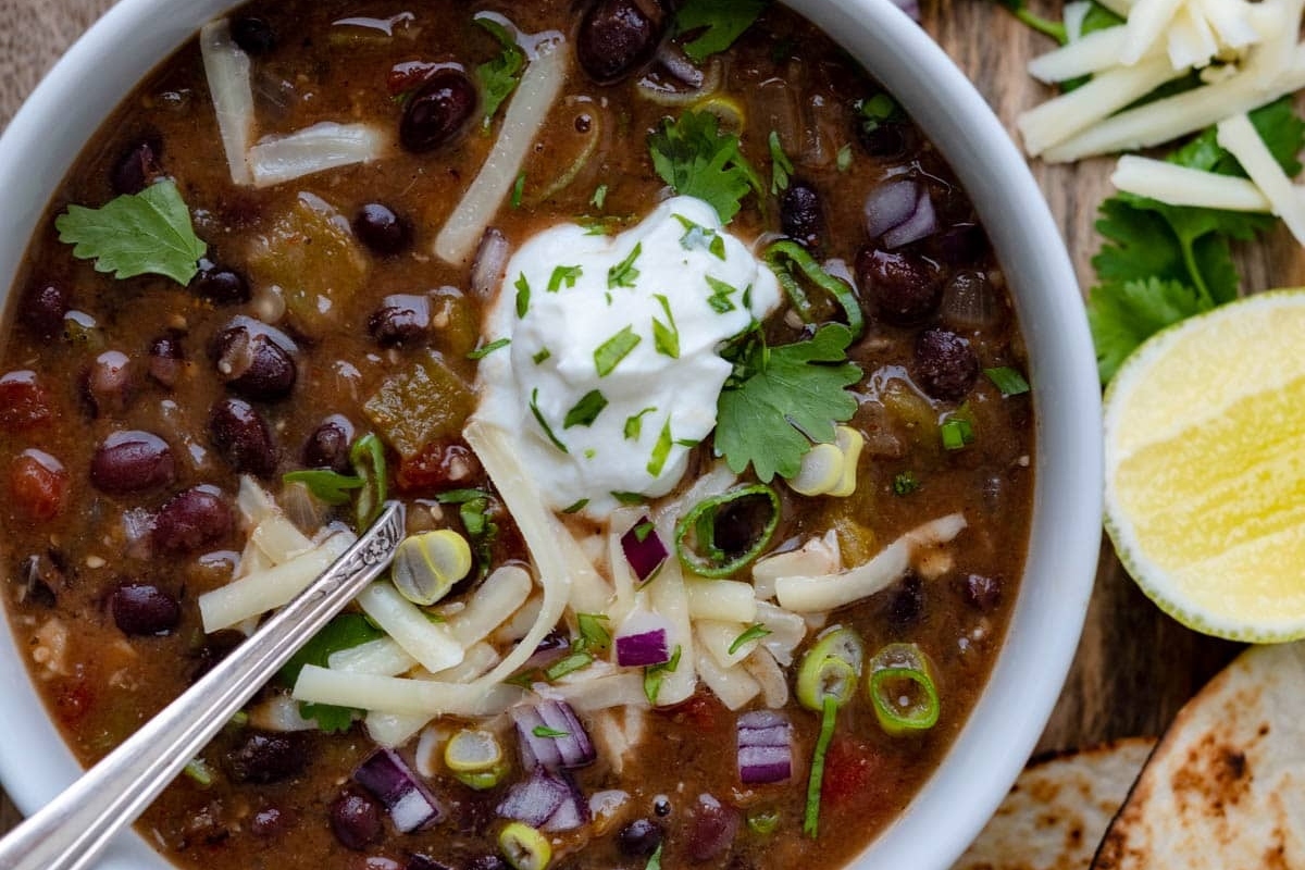 Mexican black bean soup with tortillas and sour cream, perfect for those looking for delicious chili recipes.