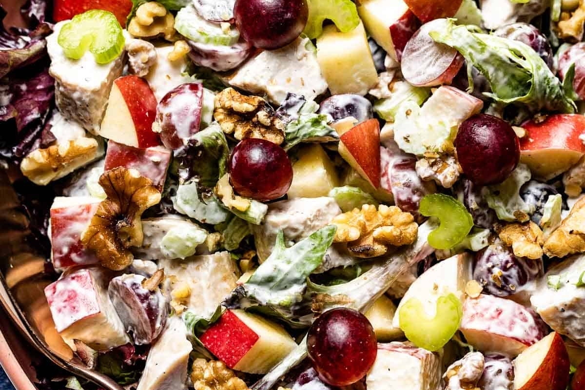 A main dish salad consisting of chicken salad with apples, walnuts, and grapes.