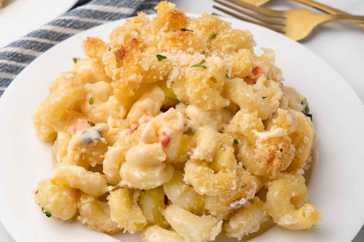 Creamy macaroni and cheese topped with truffle oil on a white plate.