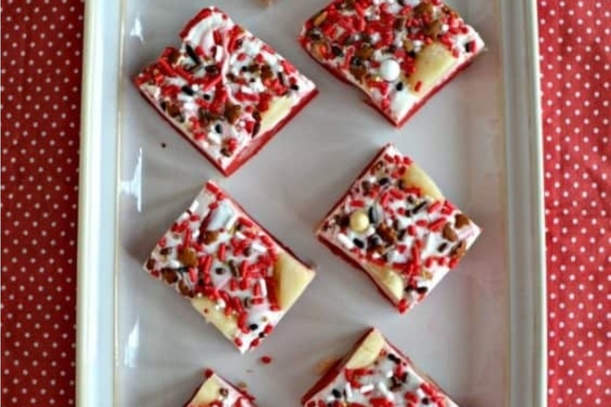 Festive red velvet squares on a white plate.