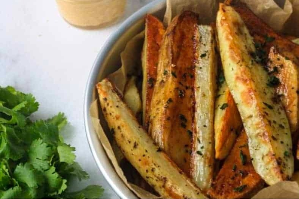 Truffle oil-infused sweet potato fries in a bowl with a dipping sauce.