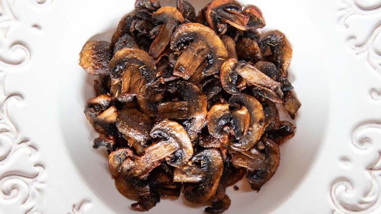 Air-fried mushrooms in a white bowl on a table.