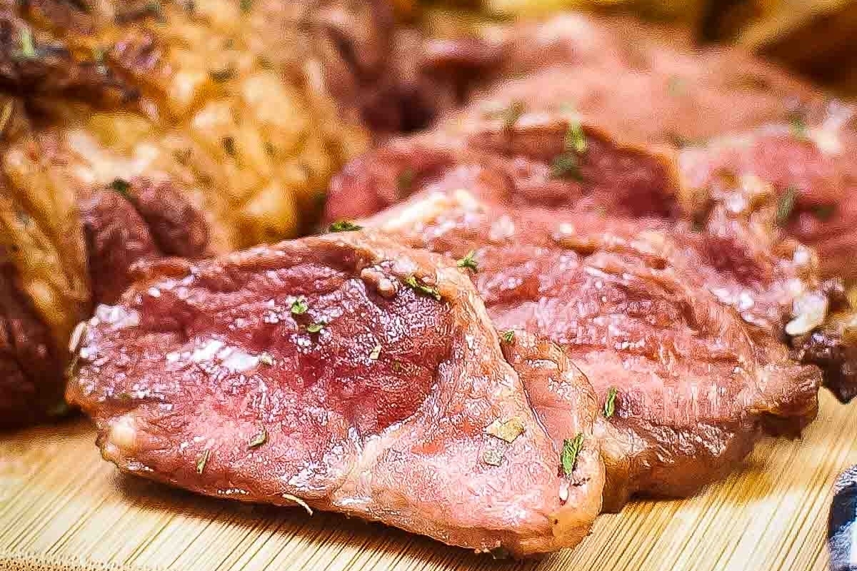 An elegant piece of meat on a simple wooden cutting board.