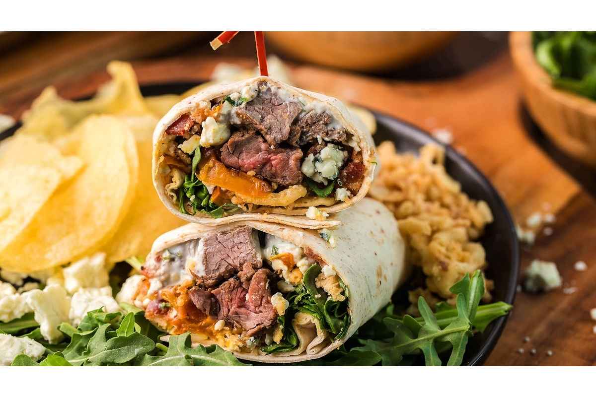 A healthy burrito with high protein meat and vegetables on a plate.