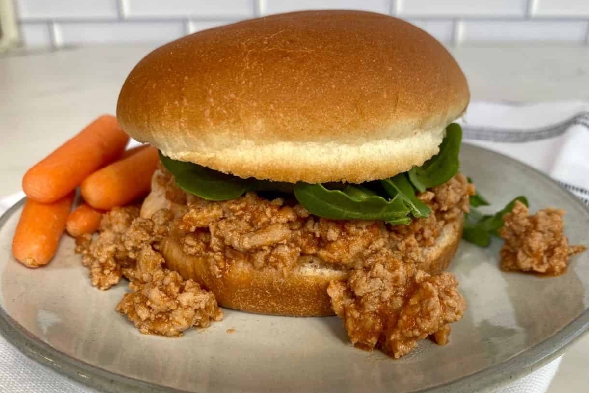 A plate with a burger and carrots, perfect for Game Day main dishes.