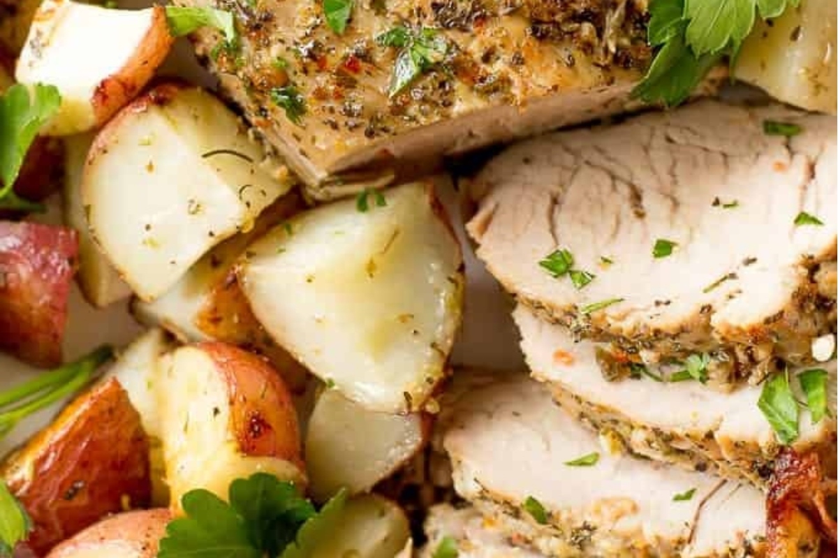Winter dinner featuring pork tenderloin with potatoes and herbs on a plate.