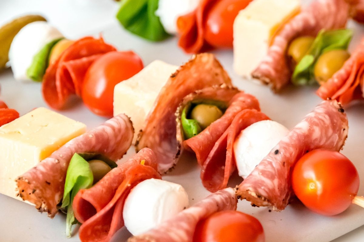 Bite-sized skewers with meat, cheese, tomatoes and olives for game day.