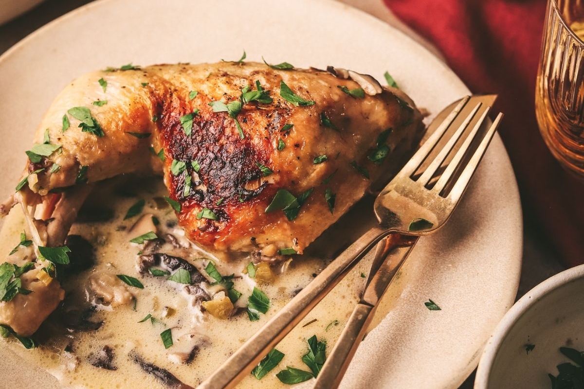 Chicken thighs and mushrooms cooked in a skillet.