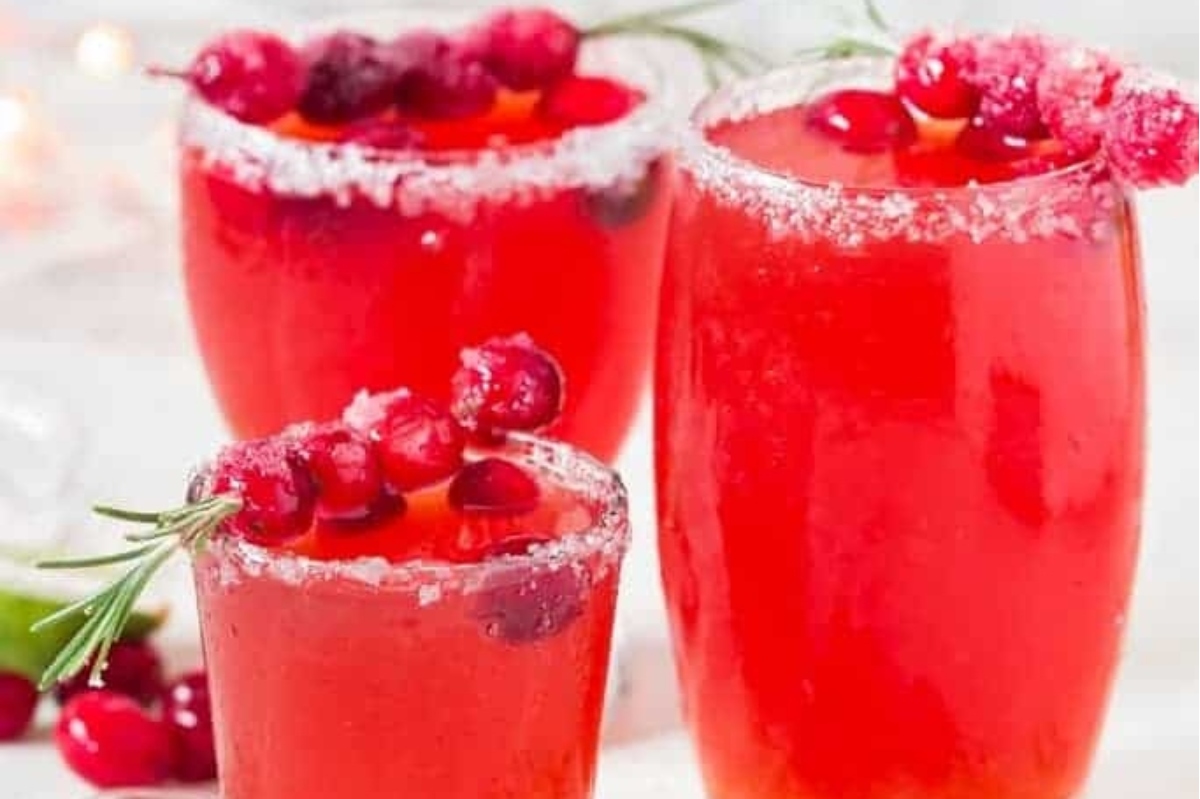 Valentine's Day cocktails featuring three margaritas with cranberries and sprigs of rosemary.