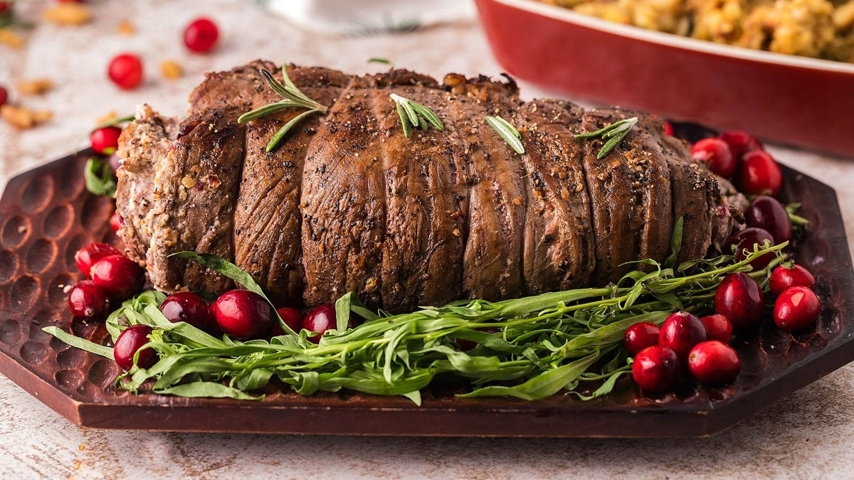 A simple and elegant roast with cranberries on a plate.