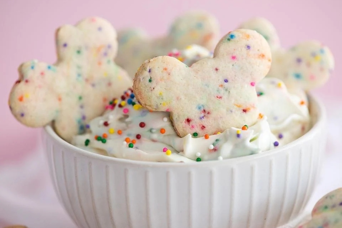 Cream cheese Mickey mouse cookies in a white bowl with sprinkles.
