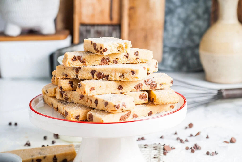 A stack of Christmas cookie bars on a white plate.