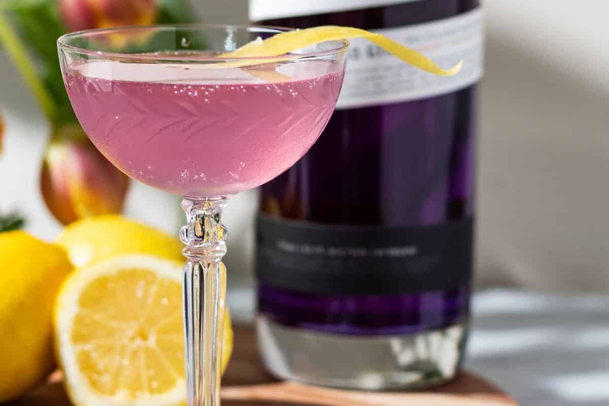 A festive Valentine's Day cocktail adorned with pink lemons and accompanied by a bottle of Johnnie Walker.