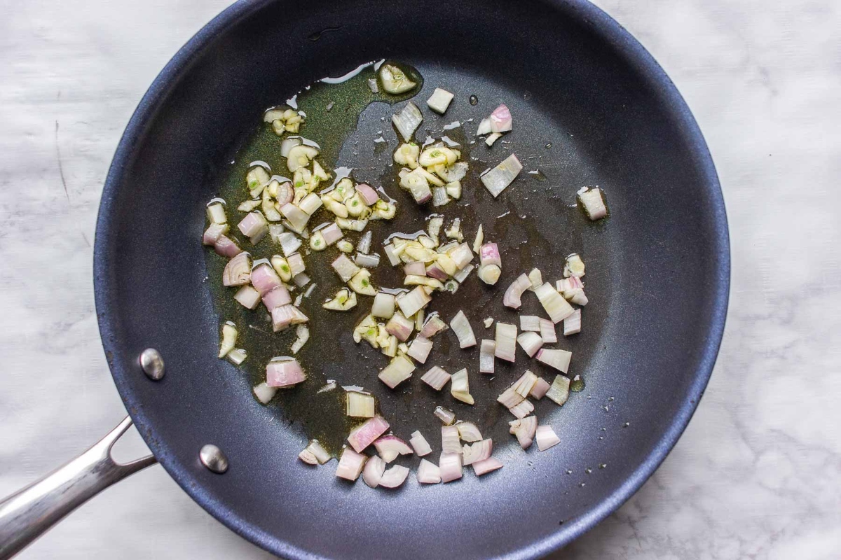 Pasta with onion and garlic cooked in a frying pan.
