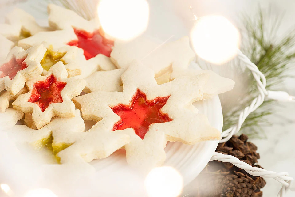 A plate of freezable Christmas cookies decorated with jelly and pine cones.