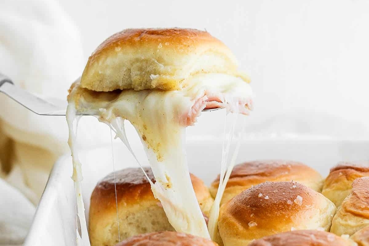 These game day ham and cheese sliders are taken to the next level by being dipped in melted cheese.