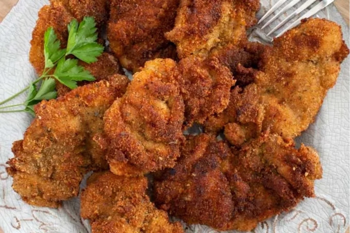 Fried chicken on a plate with parsley, perfect for game day.