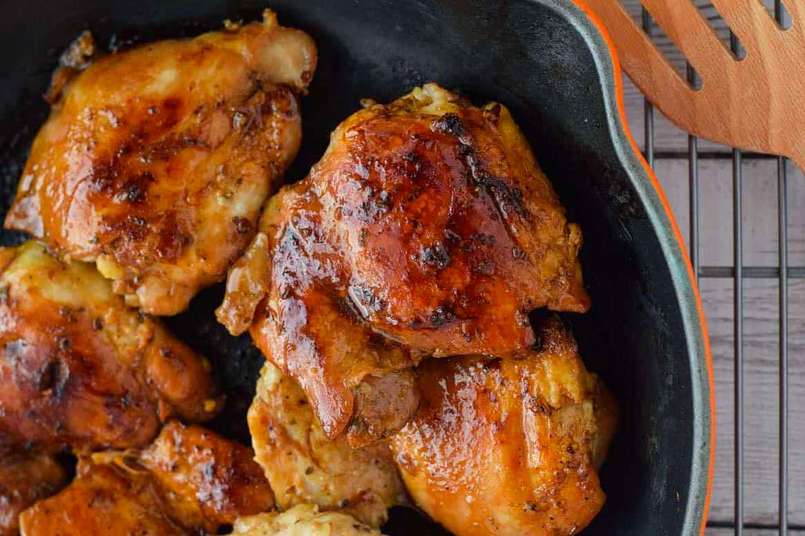 Chicken in a skillet with sauce on it.