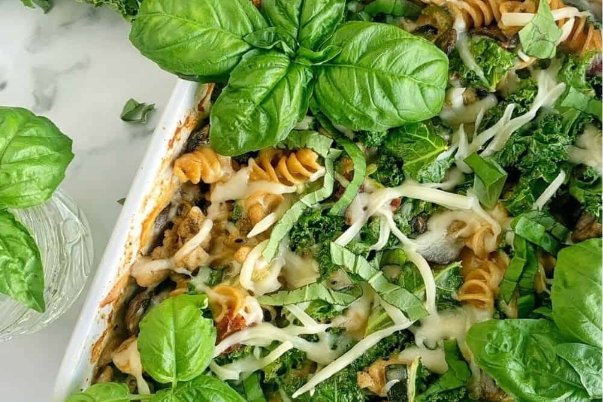 A Make Ahead pasta dish with greens, served in a white baking dish.