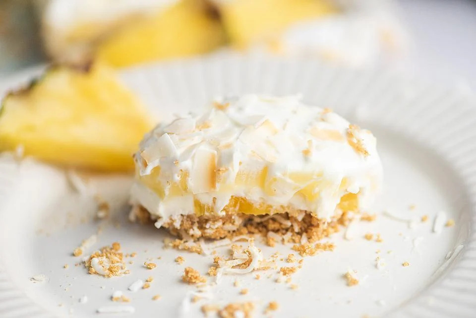 A delicious pineapple cake slice served on a pristine white plate.